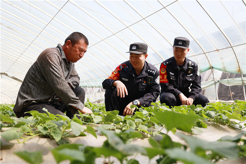 民警向群众询问庄稼长势.jpg