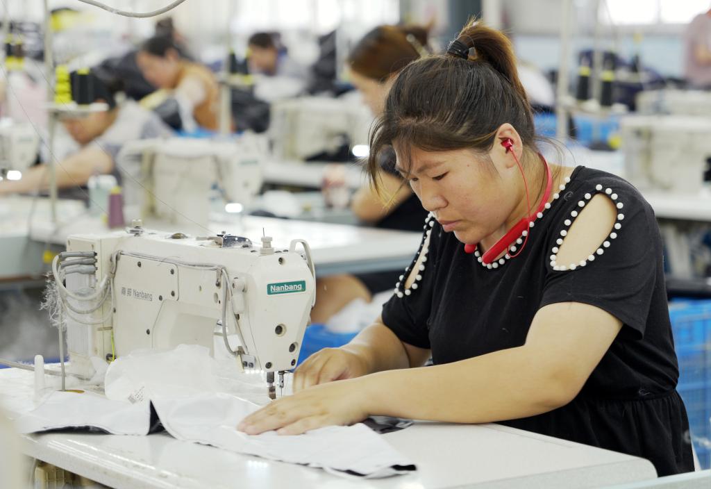 5月20日，村民在李寨村服装加工厂内忙碌。河南省周口市沈丘县冯营镇李寨村地处豫东平原。近年来，乘着脱贫攻坚与乡村振兴政策的东风，李寨村积极探索产业发展模式，通过“龙头企业+村集体经济+农户”的方式，逐渐发展形成肉牛养殖、设施农业、服装加工、康养民宿等产业，以产业振兴助力乡村振兴。新华社记者 李嘉南 摄