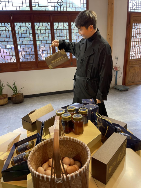 邱黎辉在展示农副产品。刘军国摄