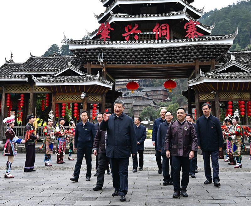 △3月17日下午，习近平总书记在贵州黔东南州黎平县肇兴侗寨考察时，在寨门口向身着民族盛装欢迎的村民挥手致意。